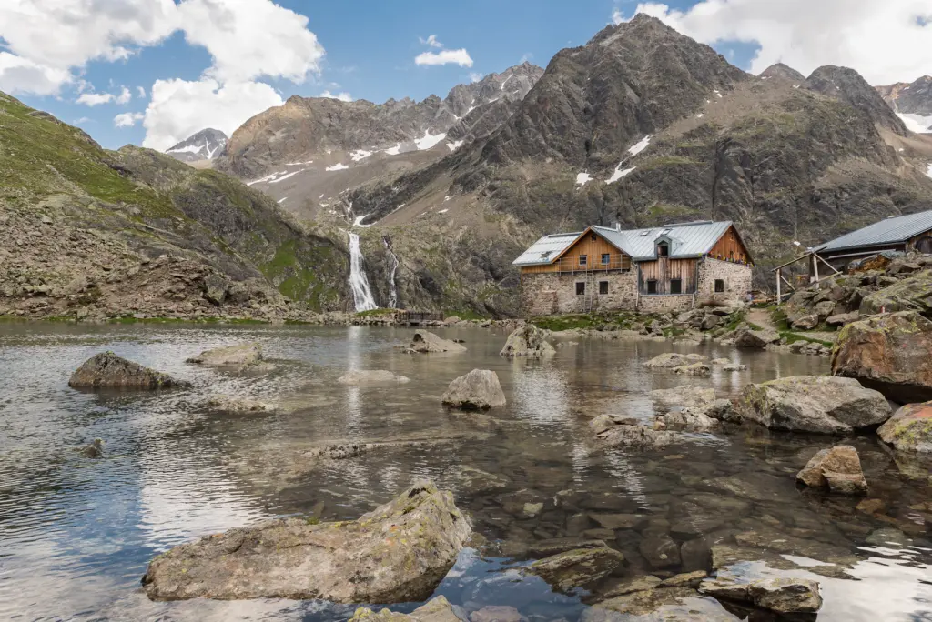 Stone mountain hut beside an alpine stream